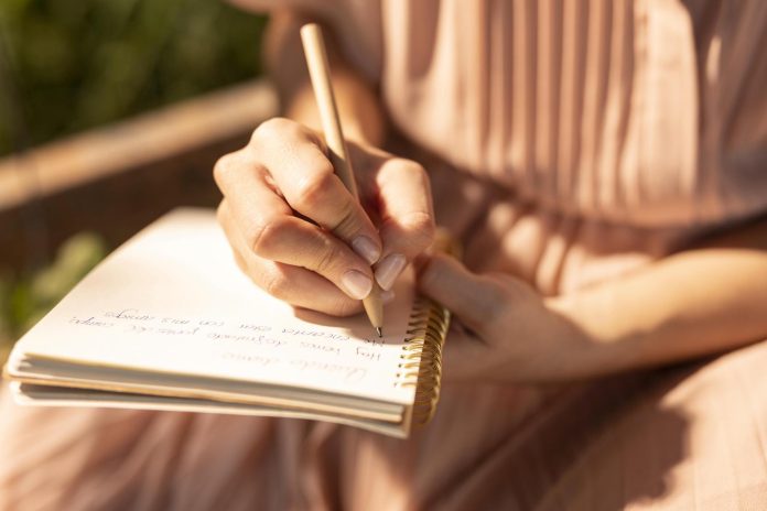 close up hand writing notebook