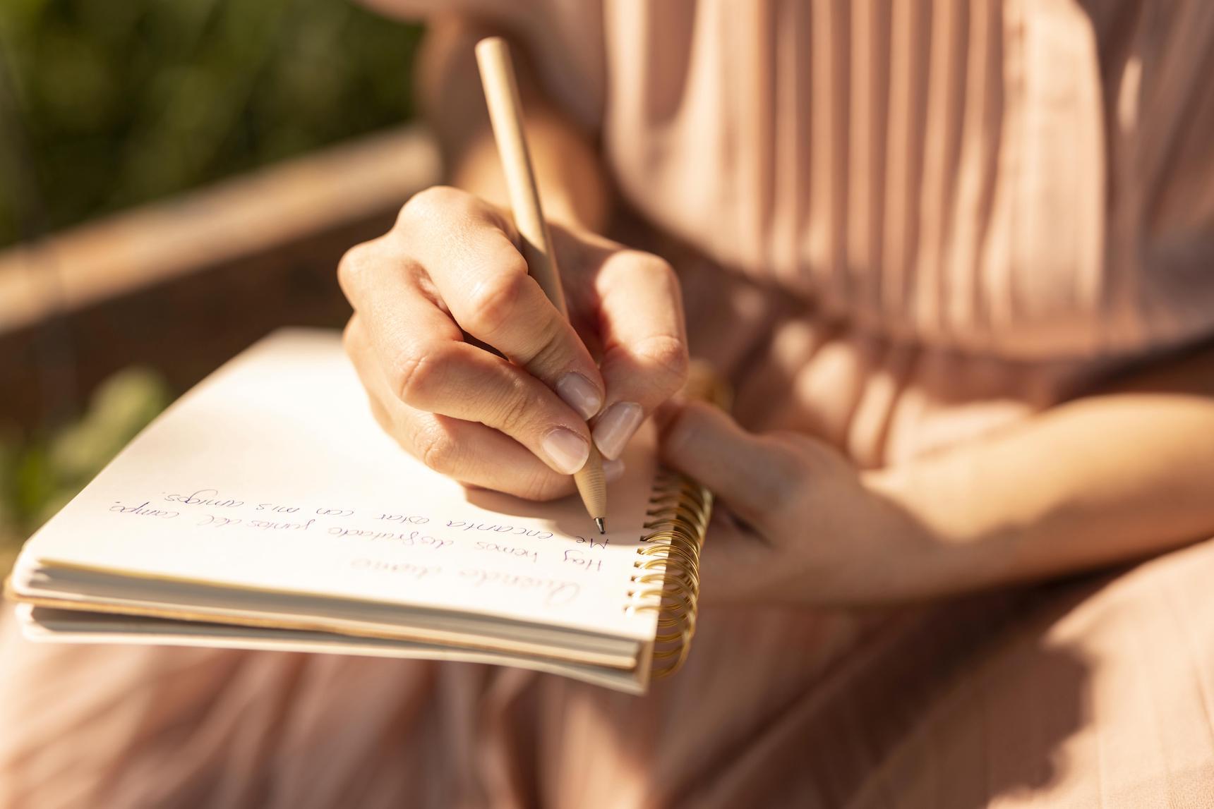 close up hand writing notebook